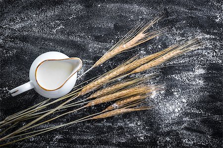 milk jug and ears of wheat on a black  textured table Stock Photo - Budget Royalty-Free & Subscription, Code: 400-07985573