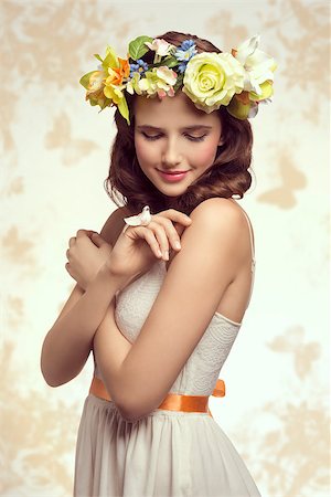 simsearch:400-07986693,k - Attractive, brunette spring woman in white dress. She has got little bird on her finger and wreath of flowers on her head. Stock Photo - Budget Royalty-Free & Subscription, Code: 400-07986693