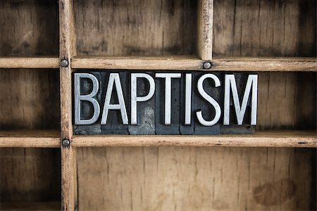 The word "BAPTISM" written in vintage metal letterpress type in a wooden drawer with dividers. Stockbilder - Microstock & Abonnement, Bildnummer: 400-07986796