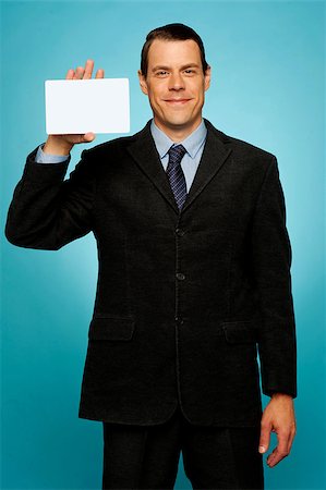 Isolated corporate man holding blank placard, showing it to camera Stock Photo - Budget Royalty-Free & Subscription, Code: 400-07987473