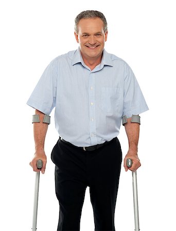 simsearch:400-07987656,k - Senior man standing with support of crutches isolated against white background Stock Photo - Budget Royalty-Free & Subscription, Code: 400-07987655