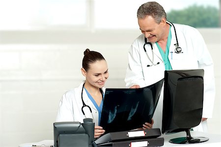 Team of surgeons discussing x-ray report in their chamber. All looks fine in report Stock Photo - Budget Royalty-Free & Subscription, Code: 400-07987712