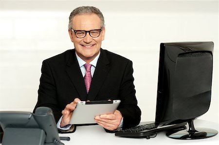 digital experience - Aged businessman in glasses using tablet sitting in office Stock Photo - Budget Royalty-Free & Subscription, Code: 400-07987742