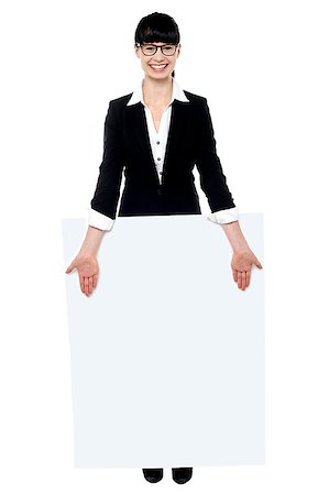 Pretty female executive standing behind blank banner ad isolated against white Stock Photo - Budget Royalty-Free & Subscription, Code: 400-07988687