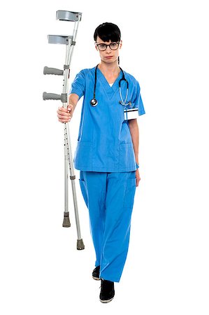 simsearch:400-07987656,k - Sad doctor holding up crutches in hand and walking towards the camera. Stock Photo - Budget Royalty-Free & Subscription, Code: 400-07988738