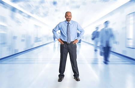 simsearch:400-07978342,k - Full body Indian businessman standing at corridor, inside business building with motion blurred people as background. Photographie de stock - Aubaine LD & Abonnement, Code: 400-07989051