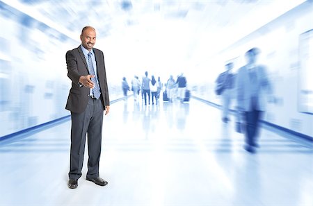 Full body Indian businessman offering hand shake at corridor, inside business building with motion blurred people as background. Stock Photo - Budget Royalty-Free & Subscription, Code: 400-07989067