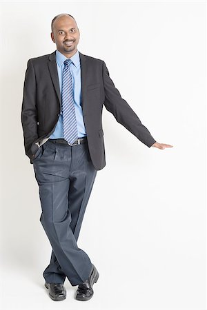 simsearch:400-07978342,k - Full body Asian Indian businessman putting hand on invisible banner over plain background Photographie de stock - Aubaine LD & Abonnement, Code: 400-07989074