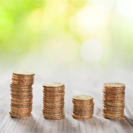 Coins stack in row on wooden background, financial concept. Focus on foreground with blur nature green background. Stock Photo - Budget Royalty-Free & Subscription, Code: 400-07989908
