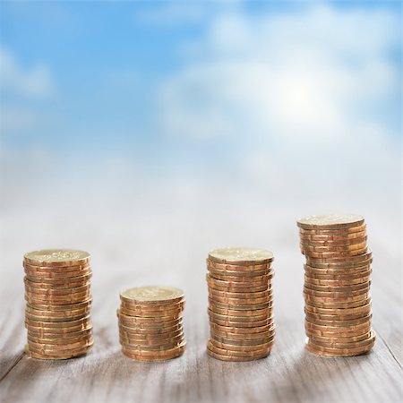 Coins stack in row on wooden background, financial concept. Focus on foreground with blur blue sky background. Stock Photo - Budget Royalty-Free & Subscription, Code: 400-07989910