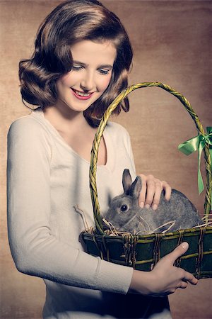 simsearch:400-08036285,k - Sweet, beautiful, adorable, happy brunette woman is holding a easter basket with fluffy, cute rabbit. Stockbilder - Microstock & Abonnement, Bildnummer: 400-07983483