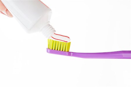 Red and white striped toothpaste on green and purple toothbrush isolated on white background. Dental care concept. Stock Photo - Budget Royalty-Free & Subscription, Code: 400-07994091