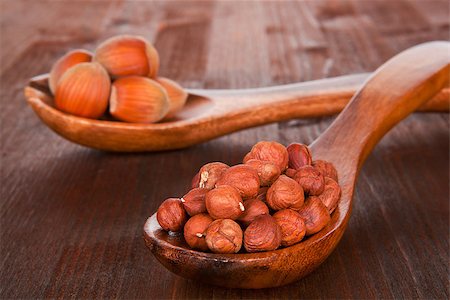 simsearch:400-05309215,k - Whole hazelnut and hazelnut seed on wooden spoons on dark brown wooden background. Culinary nuts. Fotografie stock - Microstock e Abbonamento, Codice: 400-07994441