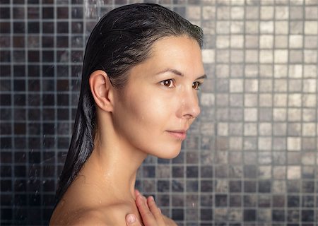 Attractive woman washing her hair in the shower rinsing it off under the spray of water looking away in a relaxed manner in a hair care, beauty and hygiene concept Stock Photo - Budget Royalty-Free & Subscription, Code: 400-07994492