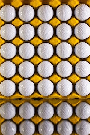 Golf balls in paper carton for eggs on a glass desk Stock Photo - Budget Royalty-Free & Subscription, Code: 400-07994921