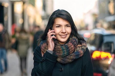 Smiling Young Woman in Autumn Fashion Talking on Phone While Walking at the City Fotografie stock - Microstock e Abbonamento, Codice: 400-07995538