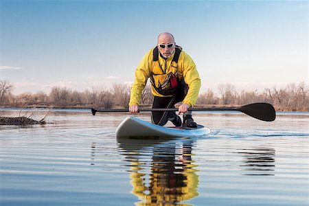 simsearch:400-07795226,k - Senior male on stand up paddling (SUP) board. Early spring on calm lake in Colorado. Foto de stock - Royalty-Free Super Valor e Assinatura, Número: 400-07996535