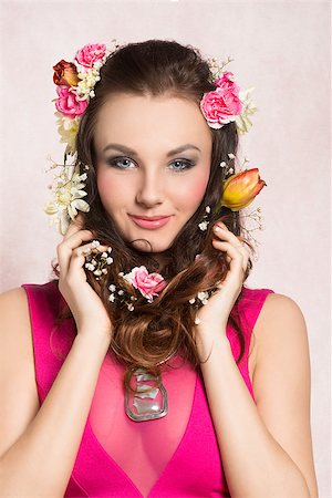 simsearch:400-07986693,k - Pretty, natural, cheerful model with brown, curly hair with spring flowers. She wears pink dress with transparent part and nice silver necklace. Stock Photo - Budget Royalty-Free & Subscription, Code: 400-07997350