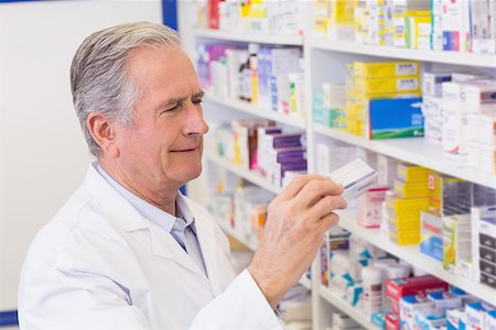 senior man taking photo alone - Senior pharmacist taking medicine from shelf at the hospital pharmacy Stock Photo - Budget Royalty-Free & Subscription, Code: 400-07990510