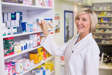 simsearch:6109-08537870,k - Junior pharmacist taking medicine from shelf at the hospital pharmacy Stock Photo - Budget Royalty-Free & Subscription, Code: 400-07990597