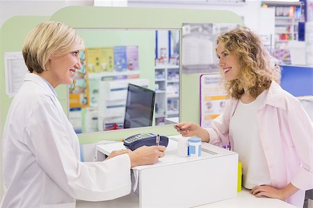 Pharmacist writing prescription in front of a customer in the pharmacy Stock Photo - Budget Royalty-Free & Subscription, Code: 400-07990620
