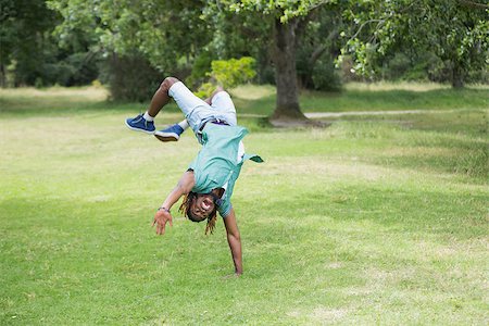 salto - Hipster doing back flip in the park on a sunny day Stockbilder - Microstock & Abonnement, Bildnummer: 400-07990934