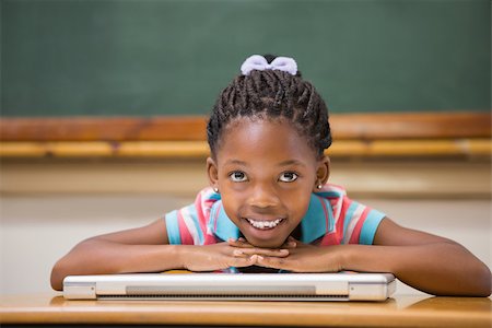 simsearch:400-07991069,k - Smiling pupil sitting at her desk at the elementary school Foto de stock - Royalty-Free Super Valor e Assinatura, Número: 400-07990987