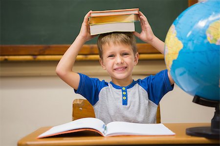 simsearch:400-07991069,k - Pupil holding books on his head at elementary school Foto de stock - Royalty-Free Super Valor e Assinatura, Número: 400-07990980