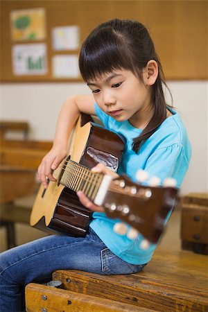 simsearch:400-07991069,k - Cute pupil playing the guitar at elementary school Foto de stock - Royalty-Free Super Valor e Assinatura, Número: 400-07991060