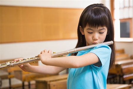 simsearch:400-07991069,k - Cute pupil playing flute in classroom at the elementary school Foto de stock - Royalty-Free Super Valor e Assinatura, Número: 400-07991061