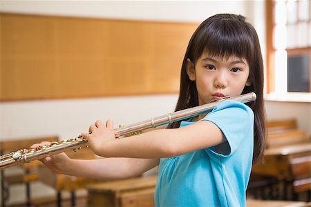 simsearch:400-07991069,k - Cute pupil playing flute in classroom at the elementary school Foto de stock - Royalty-Free Super Valor e Assinatura, Número: 400-07991062