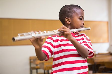 simsearch:400-07991069,k - Cute pupil playing flute in classroom at the elementary school Foto de stock - Royalty-Free Super Valor e Assinatura, Número: 400-07991063