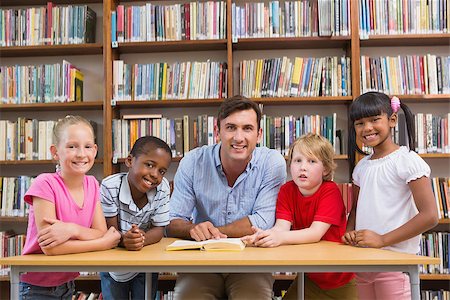 simsearch:400-07991158,k - Teacher and pupils smiling at camera at library at elementary school Stock Photo - Budget Royalty-Free & Subscription, Code: 400-07991153