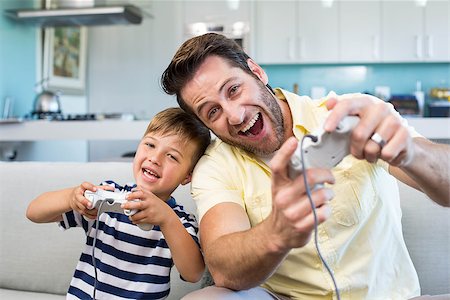 sofa two boys video game - Father and son playing video games together at home in the living room Stock Photo - Budget Royalty-Free & Subscription, Code: 400-07991315