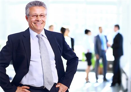 Successful business man standing with his staff in background at office Stock Photo - Budget Royalty-Free & Subscription, Code: 400-07993225
