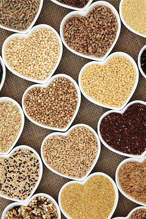 simsearch:400-07993665,k - Grain and cereal food selection in heart shaped porcelain bowls over hessian background. Fotografie stock - Microstock e Abbonamento, Codice: 400-07993665