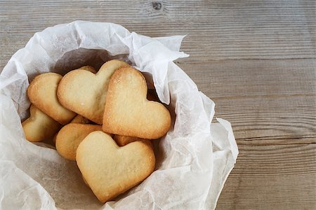 decoration of heart shape object on paper - Cookies in the form of hearts in a paper wrapper on a wooden background. Top view. Stock Photo - Budget Royalty-Free & Subscription, Code: 400-08014326