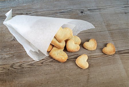 Delicious sweet cookies in the form of hearts in a paper wrapper on a wooden background. Stock Photo - Budget Royalty-Free & Subscription, Code: 400-08014328