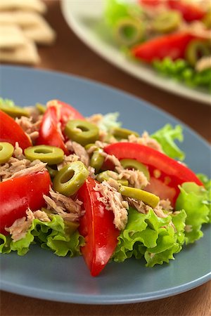 simsearch:400-08014878,k - Fresh tuna, tomato and green olive salad served on lettuce leaf on blue plate (Selective Focus, Focus on the front of the olive in the middle of the salad) Stock Photo - Budget Royalty-Free & Subscription, Code: 400-08014889