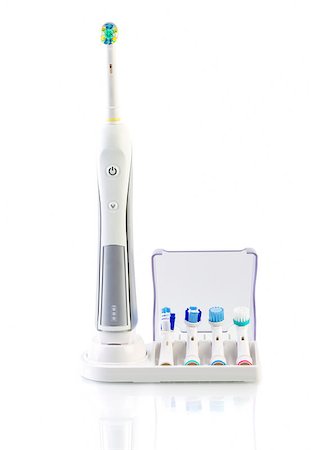 Electric toothbrush with stand charger and four spare brushes on white background Foto de stock - Super Valor sin royalties y Suscripción, Código: 400-08015248