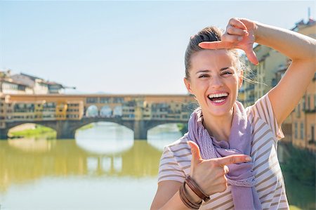 simsearch:400-08020855,k - Portrait of happy young woman standing on bridge overlooking ponte vecchio in florence, italy and framing Stockbilder - Microstock & Abonnement, Bildnummer: 400-08016314