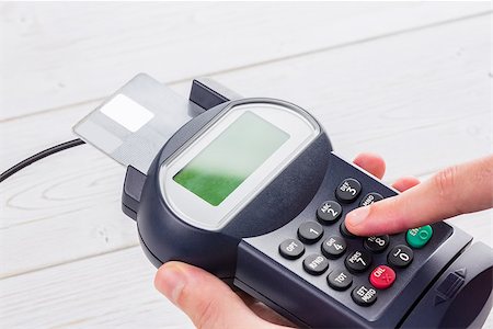 simsearch:400-08017447,k - Man entering his pin on terminal on a wooden table Fotografie stock - Microstock e Abbonamento, Codice: 400-08017445