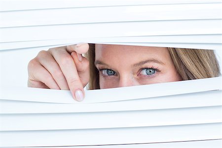 peeking store window - Woman peering through roller blind on white background Photographie de stock - Aubaine LD & Abonnement, Code: 400-08017827