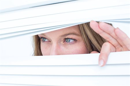 peeking store window - Woman peering through roller blind on white background Photographie de stock - Aubaine LD & Abonnement, Code: 400-08017830