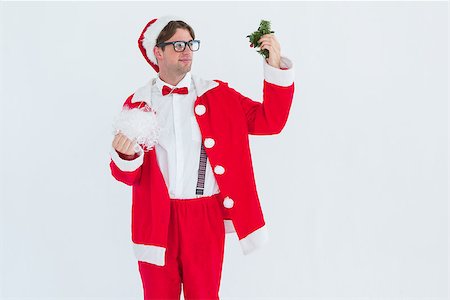 Geeky hipster in santa costume looking at mistletoe on white background Stock Photo - Budget Royalty-Free & Subscription, Code: 400-08017987