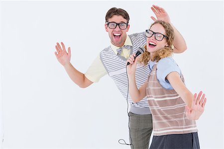 simsearch:400-08380794,k - Geeky hipster couple singing into a microphone on white background Stockbilder - Microstock & Abonnement, Bildnummer: 400-08018062