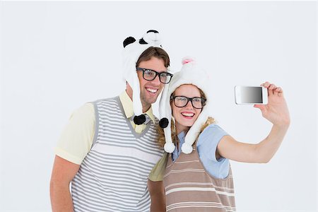 simsearch:400-08380794,k - Geeky hipster couple taking selfie with smartphone on white background Stockbilder - Microstock & Abonnement, Bildnummer: 400-08018076
