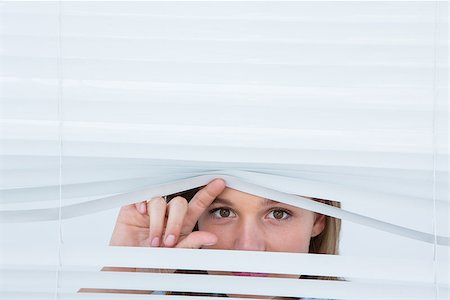 peeking store window - Woman peering through roller blind on white background Photographie de stock - Aubaine LD & Abonnement, Code: 400-08018352