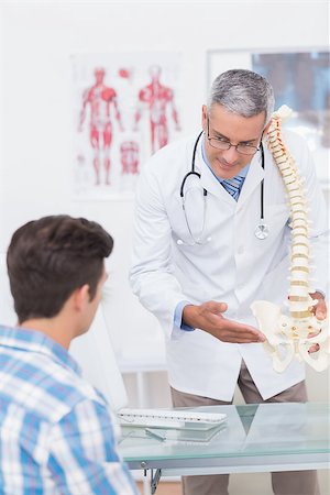 doctor with spine model - Doctor explaining a spine model to patient in medical office Stock Photo - Budget Royalty-Free & Subscription, Code: 400-08018434