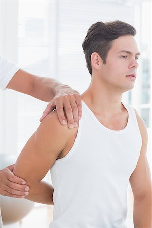 simsearch:400-04337005,k - Doctor stretching a young man arm in medical office Foto de stock - Super Valor sin royalties y Suscripción, Código: 400-08018576